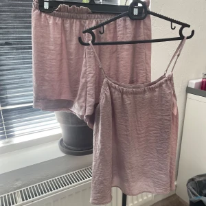 Ett pyjamas sätt från H&M - Säljer ett pyjamas sätt från H&M i en mjuk och lätt material. Sättet har en enkel och avslappnad passform och är perfekt för varma dagar. Stilren design utan mönster eller extra detaljer.