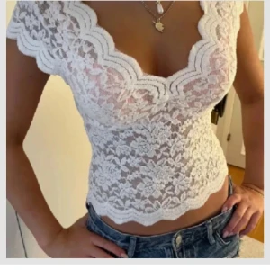 Vit spetsblus från Zara - Säljer en vacker vit spetsblus från Zara med korta ärmar och djup v-ringning. Blusen har ett fint blommönster och vågiga kanter som ger en romantisk touch. Perfekt för att lyfta vilken outfit som helst! 💫de två första bilderna är lånade och dom tre sista är mina 💕
