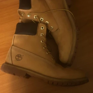 Timberland boots - Säljer ett par klassiska beige boots från Timberland med snörning och rund tå. Tillverkade i äkta skinn med robust sula, perfekta för höst och vinter. stl.39/40