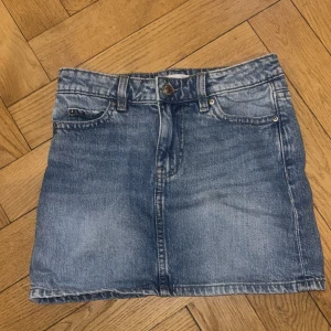 Blå jeanskjol från Gina tricot - Snygg blå jeanskjol från Gina tricot med fickor på baksidan perfekt till våren och sommaren.💕Endast använd 1 gång. 💕