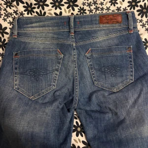  Pepe Jeans - Snygga blå jeans från Pepe Jeans med slitna detaljer och broderade bakfickor, säljer pga att de ej kommer till användning, inga defekter!💕