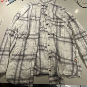 Rutig skjorta från Hollister - Säljer en stilren rutig skjorta från Hollister i en mjuk bomullskvalitet. Skjortan har en boyfriend fit och är långärmad med knappar framtill. 