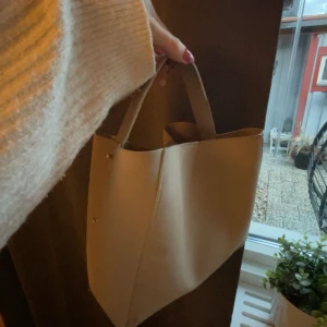 Beige axelväska - Snygg beige axelväska i stilren design. Perfekt storlek när man inte vill ha för stor väska! 