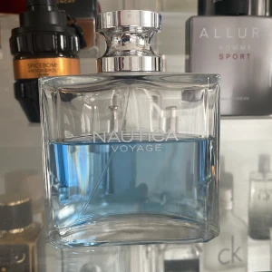 Nautica Voyage Eau de Toilette - Säljer en fräsch och maskulin Nautica Voyage Eau de Toilette. Flaskan är elegant med en klar design och innehåller en ljusblå doft. Perfekt för den som söker en uppfriskande och maritim känsla. Runt 55 ml kvar, avgör själv!🤩😀🤩