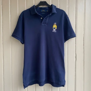 Ralph Lauren polo bear piké - En fin piké i väldigt bra skick bortsett från det lilla hålet vid slutet av ena ärmen och två små till skador nere på pikén. Du kan se på de sista bilderna. 👕  Måtten är 70 i längd och 45 i axelbredd.  Nypriset för denna piké ligger på ca 1400kr men eftersom ett par små skador har jag valt att sänka priset rejält.💰  Om du har frågor tveka inte på att skriva!!💬💬 