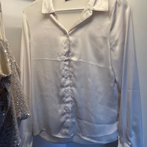 Vit sidenblus - Elegant vit blus i siden med långa ärmar och klassisk krage. Perfekt för en stilren look.