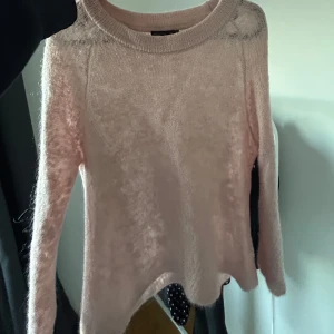 Rosa stickad tröja - Säljer en mjuk och mysig rosa stickad tröja med rund halsringning. Tröjan har lite kortare ärmar och en lätt transparent look. Perfekt för kyliga dagar! (I mohair) osäker på storlek men sitter som en S!