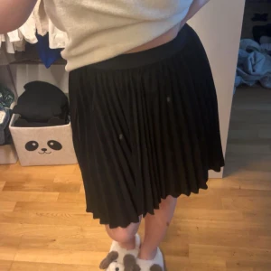 Svart plisserad kjol - Snygg svart plisserad kort kjol. (Den har inga fläckar utan de är smuts på min spegel)! Lappen är tyvärr bortklippt så vet inte märket. 