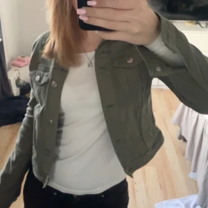 Grön jeansjacka - Snygg grön jeansjacka med knappar framtill. Jackan har en croppad passform och långa ärmar. Perfekt för vår och sommar.