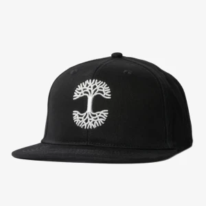 Svart keps med broderat träd - Snygg svart keps från Oaklandish med ett broderat träd i vitt framtill. Kepsen har en justerbar rem baktill för perfekt passform. Perfekt för en stilren look.