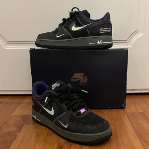 Nike Air Force 1 '07 LVB - Säljer ett par svarta Nike Air Force 1 '07 LVB med lila detaljer som är en limiterad modell. De är använda en gång så de är så gott som nya.
