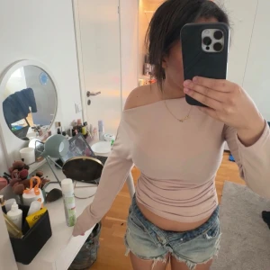 Beige offshoulder topp - Säljer en stilren beige offshoulder topp med långa ärmar. Perfekt för en trendig look.💘💘💘