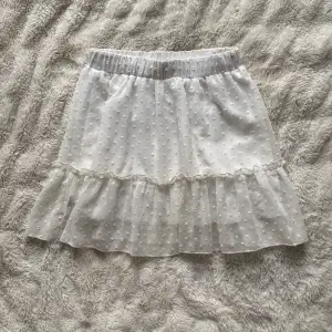 Säljer denna fina vita kortkjolen med volangdetaljer och prickigt mönster. Passar xs-m, bra skick då den bara använts några gånger💗
