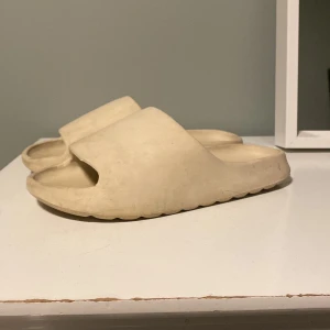 Beige sandaler - Säljer ett par bekväma beige sandaler med öppen tå. Perfekta för sommardagar och avslappnade tillfällen. De har en enkel och stilren design som passar till det mesta.