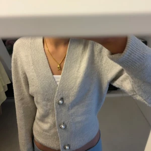 Beige kofta med pärlknappar - Säljer en fin beige kofta med v-ringning och dekorativa pärlknappar. Perfekt för höst och vår!