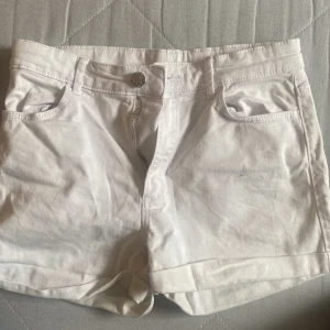 Vita shorts med dragkedja - Snygga vita shorts med dragkedja och knapp framtill. De har en klassisk femficksdesign och är perfekta för varma dagar. Passar till allt och ger en fräsch look.