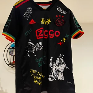 Ajax x Bob Marley fotbolls tröja  - Säljer en unik svart fotbollströja från Adidas med Bob Marley collab. Tröjan har färgglada detaljer i rött, gult och grönt samt fin tryck bå fram och baksida. 