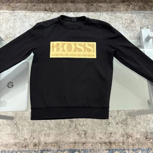 Boss tröja - Beskrivning: Säljer en Hugo Boss-tröja i storlek S. Tröjan är svart med stilren guldtext. Den är i toppskick utan några tecken på användning – ser ut som ny! Perfekt för både vardag och fest.  ✔️ Märke: Hugo Boss ✔️ Storlek: S ✔️ Färg: Svart med guldtext ✔️ Skick: 10/10 – inga tecken på användning  Pris kan diskuteras – hör av dig vid intresse!