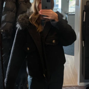 Svart jacka med pälskrage - Supersnygg stilig jacka som tyvärr inte kommer till användning och är i behov av ett nytt hem! Endast använd 1 gång. Kragen är i fuskpäls.