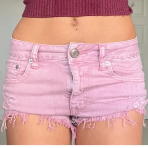 Rosa jeansshorts från American Eagle Outfitters - Snygga rosa jeansshorts från American Eagle Outfitters med fransiga kanter. De har en knapp och dragkedja framtill.