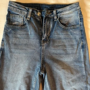 Blå jeansbyxor från SHEIN - Snygga blå jeansbyxor med klassisk femficksdesign och knappgylf från SHEIN i storlek Petite XS. De har en lätt tvättad design. Använda 1 gång. 