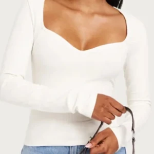 Vit ribbad långärmad topp - Helt slutsåld❤️Snygg vit ribbad topp med lång ärm och djup v-ringning. Perfekt för en stilren look.