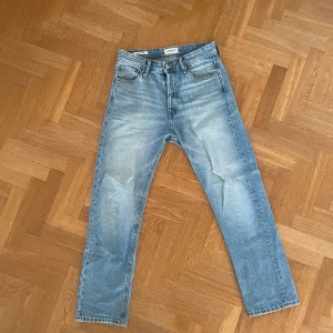Jack & Jones Jeans - Blå Jack & Jones jeans som passar till en avslappnad look. De har en klassisk femficks design och en snygg tvätt som ger en cool vintage känsla. Jeansen är storlek 27/30 men passar 29-30/30