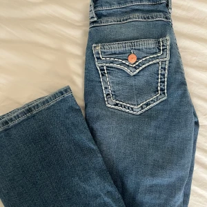Blå jeans med broderade detaljer - Snygga blå jeans med unika broderade detaljer. Bootcut och lågmidjade. Endast använda 2 gånger, inga defekter. 
