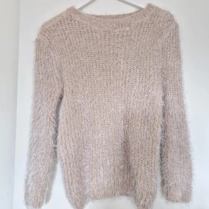 Beige fluffig stickad tröja - Mysig beige stickad tröja med fluffig textur. Perfekt för kyliga dagar med sin långärmade design och mjuka material. En stilren och bekväm tröja som passar till många tillfällen. Från Vero Moda utan lapp. Går ej att förhandla, priset är fast