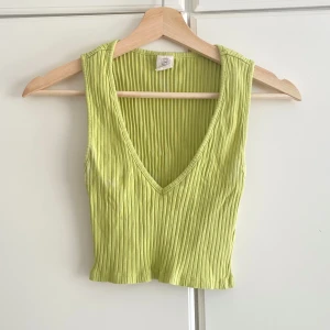 Ljusgrön ribbad linnetopp Urban Outfitters - Superfräsch ljusgrön ribbad linnetopp från Urban Outfitters. Toppen är croppad med djup v-ringning och ärmlös design, perfekt för varma dagar. Mjuk och stretchig bomull som sitter snyggt och bekvämt. Enkelt att styla till jeans eller kjol.