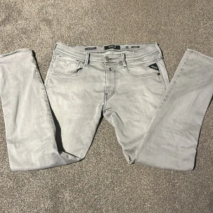 Replay Anbass ljusgrå jeans, stl 32 - Snygga ljusgrå Replay Anbass jeans i klassisk femficksmodell. Jeansen har raka ben, diskreta sömmar och detaljer som Replay-logga på fickan och bak. Tillverkade i mjukt denimtyg som sitter skönt hela dagen.
