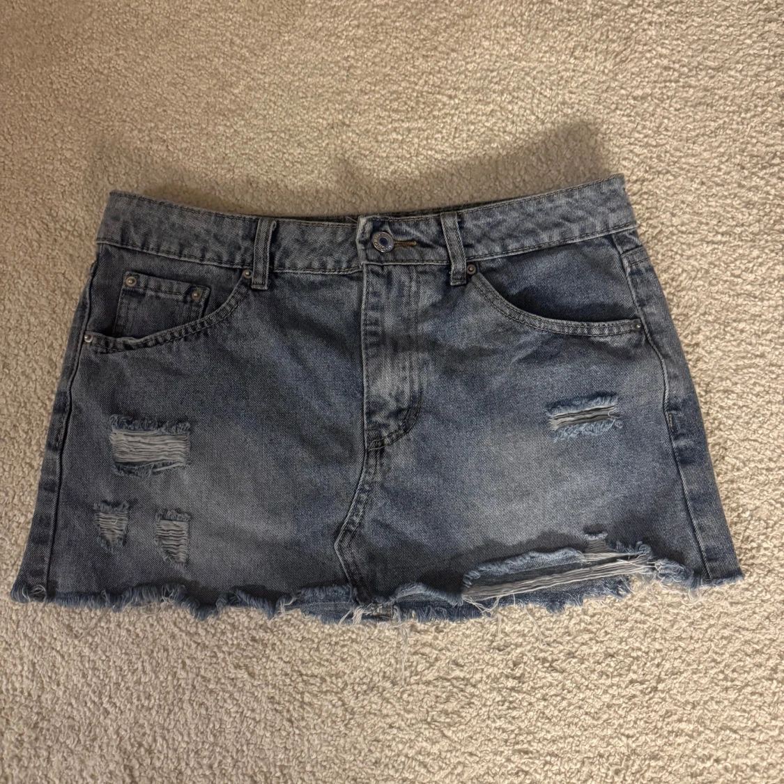 Blå jeanskjol med slitningar