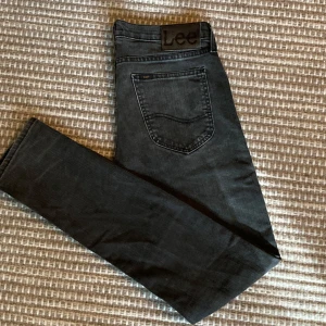 Svarta jeans Lee Luke - Snygga svarta jeans från Lee. Modellen Luke är slim fit. Jeansen är gjorda i mjuk bomullsblandning med lite stretch för extra komfort. Jag säljer nu flera Luke i samma storlek men olika färger!