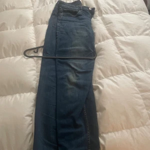 Mörkblå jeansbyxor Mustang - Snygga mörkblå jeans  med klassisk femficksdesign och diskreta slitningar framtill. Jeansen har raka ben och normal passform, perfekta för en avslappnad stil. Tillverkade i mjukt bomullsmaterial för skön känsla hela dagen.