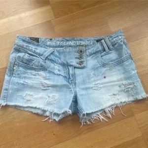 River Island ljusblå jeansshorts - Ljusblå jeansshorts från River Island med slitna detaljer, en av knapparna har en liten defekt. Priset kan diskuteras. (Lånade bilder)💕