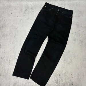 90s Levi's 501  32/34 - Svarta Vintage 90s Levi's 501 jeans med klassisk rak passform och knappgylf. Jeansen har fem fickor, ikonisk läderpatch bak och är tillverkade i slitstarkt denim. Perfekta för dig som gillar en tidlös och clean look.