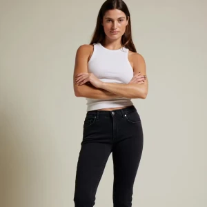 Svarta bootcut jeans  - Svarta bootcut jeans med låg midja. Fransad kant nertill. Klassisk femficksmodell i stretchig denim. Perfekta för en clean och stilren look med lite edge. Storlek waist L lenght 31