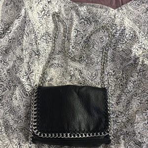 Svart axelväska med kedjedetaljer - Svart tiamo väska ifrån scorett i strl M oanvänd❣️