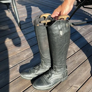 Svarta ridstövlar i skinn - Snygga svarta ridstövlar i skinn med klassisk design i storlek 39. Nypris är 1299kr. Dom är använda cirka 2 säsonger.