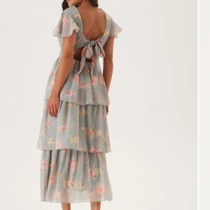 Blommig långklänning med volanger - Ny klänning med volanger från bubbleroom med knytdetalj i ryggen. Storlek: S Nypris: 900kr