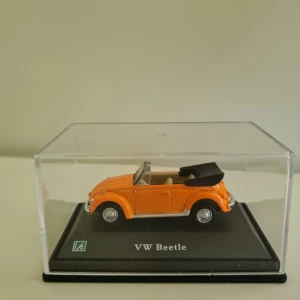 Volkswagen Beetle Cabriolet – Cararama 1:43 Samlarobjekt - Snygg och detaljerad modell av Volkswagen Beetle Cabriolet från Cararama i skala 1:43.  * Färg: Orange med svart cabriolettak * Skala: 1:43 * Märke: Cararama * Material: Metall med plastdetaljer * Levereras på original displayplatta och med skyddshölje  Perfekt som samlarobjekt eller prydnad, men kan även fungera som leksak för äldre barn.