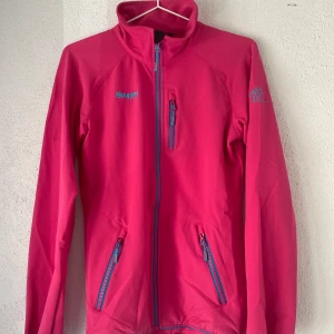 Rosa vindjacka från Bergans - Nypris 1200kr - 4-vägs stretch för full rörelsefrihet - Slitstark, snabbtorkande, vindoch vattenavvisande - Reflexdetaljer för säkrare vandringar i mörker - Helt oanvänd, sann till storlek