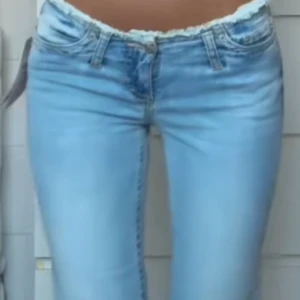 Ljusblå lågmidjade jeans - Snygga ljusblå jeans med låg midja och bootcut.  Fransig midja. Från nelly 💕 använda ett fåtal gånger så i nyskick. Nypris 699kr