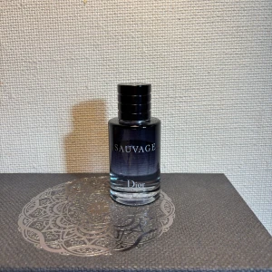 Dior Sauvage parfym 60ml - Dior Sauvage parfym i en stilren glasflaska med mörkblå till transparent färgskiftning och svart rund kork. 