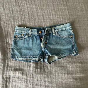 Lågmidjade jeansshorts - Snygga och unika jeansshorts med låg midja från Mustang. Det står att de är i W29, de sitter som S/36 då de är för små för mig som vanligtvis har M/38. Tveka inte att fråga om mått eller fler bilder. Skönt material och perfekta till sommaren! Det var svårt att fota den riktiga färgen men den syns bäst på andra bilden.