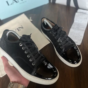 Lanvin dbb1 - Snygga svarta sneakers från Lanvin | Äkta såklart | UK 7 | Ovandel i mocka & lackad tå | Vita sulor | Svarta skosnören | Silverfärgade öljetter | Stilren & lyxig look | Kvitto från NK + påse, dustbag & box medföljer | Hör av dig vid minsta fundering💫