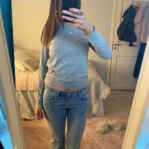 Grå tröja från H&M - Enkel och stilren grå tröja från H&M i storlek XS. Tröjan har rund hals, långa ärmar och ribbade muddar vid ärmslut och nederkant. Perfekt till jeans eller kjol för en clean look. Inga defekter!