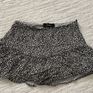 Kort mönstrad kjol  - Tunn kjol med volang, nertill, står S som storlek men passar mer en xxs. Har inbyggda shorts och dragkedja på sidan.