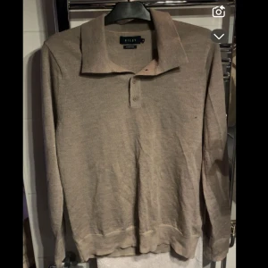 Beige pikétröja i ull från Riley - Säljer denna piké från riley i bra skick bara att den har ett litet hål som ni ser på bild ”2” sorlek m