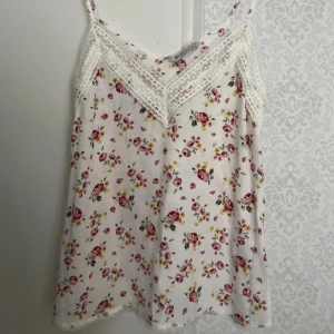 Blus blommig spets - Säljer denna jättefina blommiga blusen då den inte har kommit till användning. Aldrig använd! Den har snygga vita spets detaljer vid urringningen och längst ner. Passar xs och s. Hör gärna av dig om du har några frågor! 